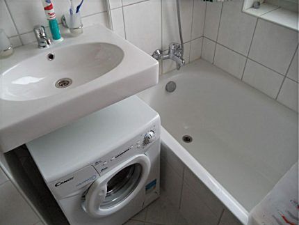 Белая навесная раковина над стиральной машиной